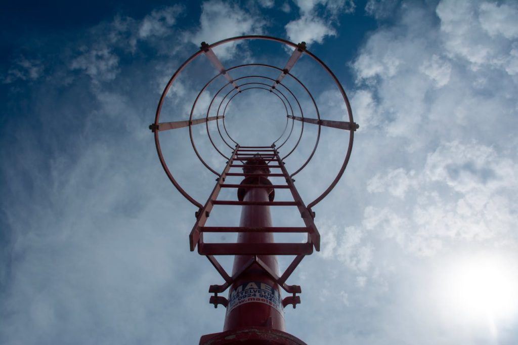 A red metal pole with a blue sky in the background